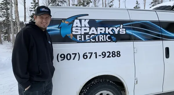 Jake Amberson, owner of AK Sparky's Electric, beside the company van in Wasilla, Alaska